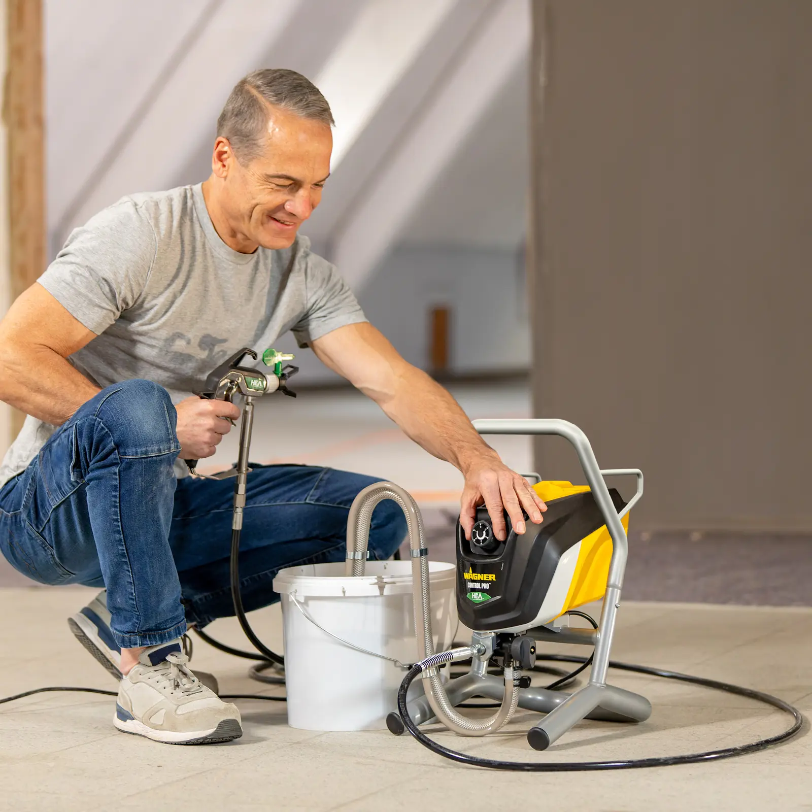 Man adjusting a Wagner Control Pro HEA paint sprayer.