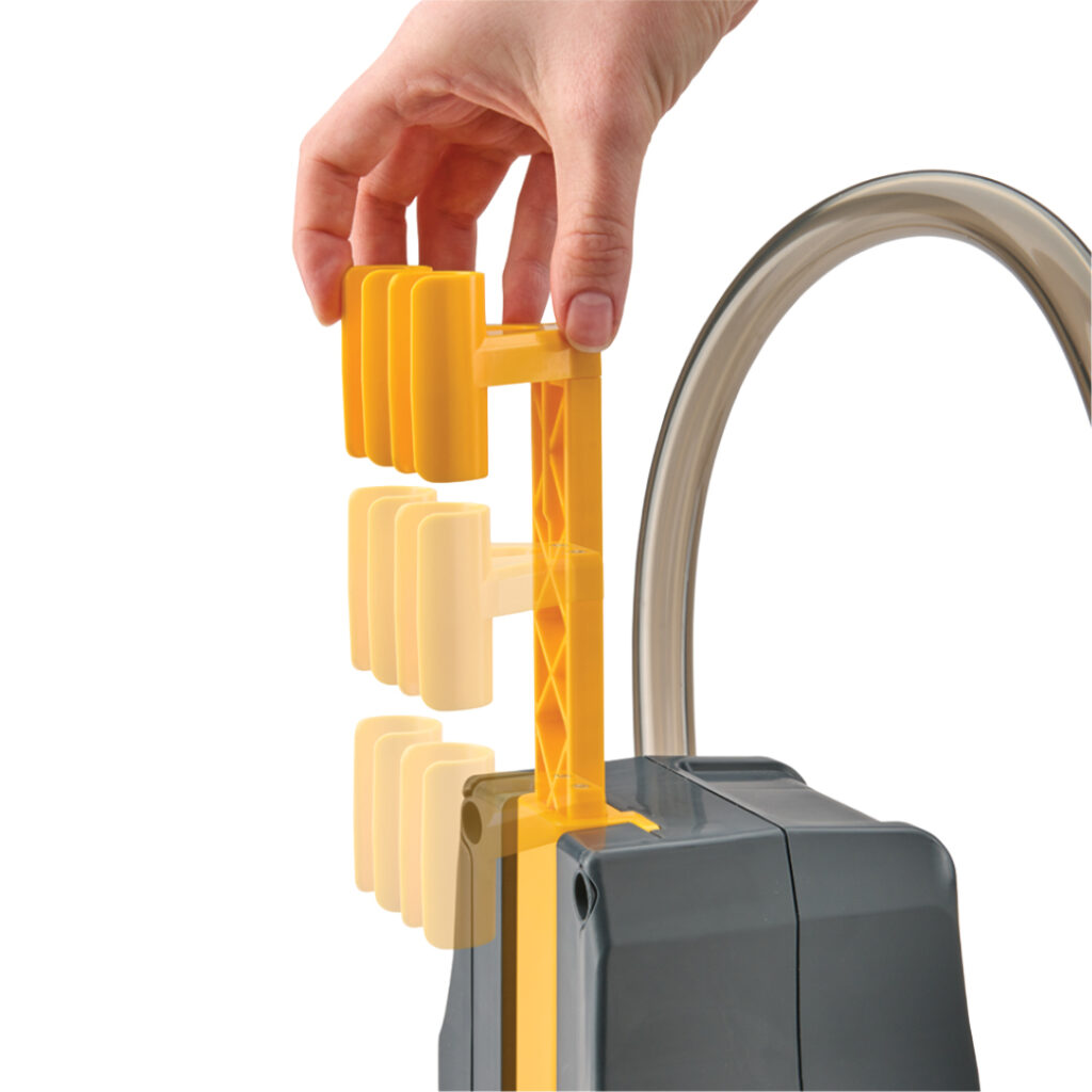 Hand slides yellow weights onto grey mechanism with tube.